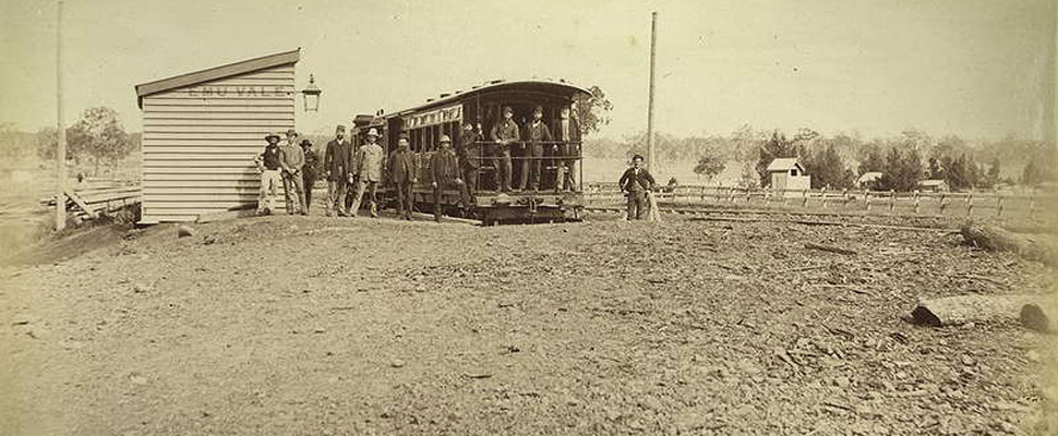 A sepia toned photograph taken at Emu Vale, a station on the former Killarney branch railway, full image description is available below.